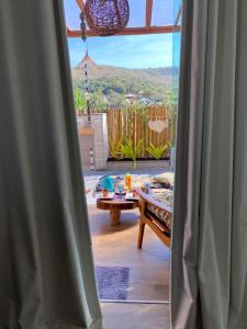 uma vista a partir de uma janela de um pátio com uma mesa em Loft Mandalua em Serra do Cipó