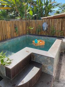une piscine dans un jardin avec une table dans l'eau dans l'établissement Loft Mandalua, à La Serra do Cipo