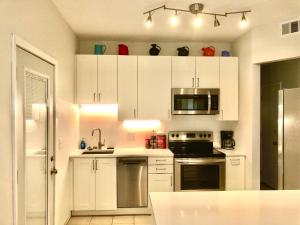 een keuken met witte kasten en een fornuis met oven bij Homey 2 bedroom Apartment, Minutes from Everything! in Minneapolis
