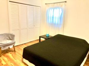 a bedroom with a bed and a chair and a window at Homey 2 bedroom Apartment, Minutes from Everything! in Minneapolis