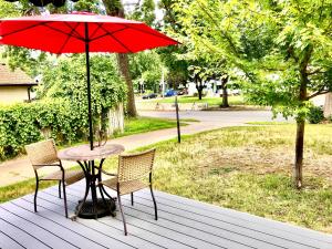 een tafel met twee stoelen en een rode paraplu op een terras bij Homey 2 bedroom Apartment, Minutes from Everything! in Minneapolis