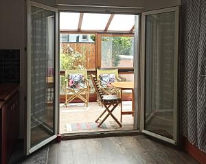 Une porte ouverte s'ouvre sur une terrasse avec une table et une chaise. dans l'établissement Un moment de douceur, à Nancy