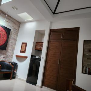 a room with two wooden doors and a kitchen at Bungalows Musch Kamala Phuket in Kamala Beach