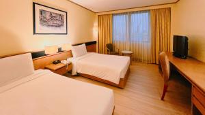Habitación de hotel con 2 camas y TV en Novotel Bangkok Bangna, en Bangna