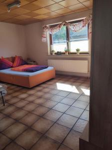 een slaapkamer met 2 bedden en een tegelvloer bij Appartement am Waldesrand in Gifhorn