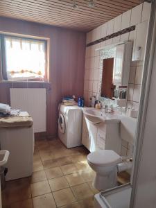 Appartement am Waldesrand في غيفهورن: حمام مع حوض استحمام وغسالة ملابس