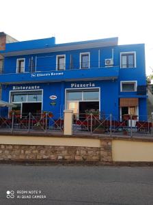 un bâtiment bleu sur le côté d'une rue dans l'établissement Eliseo's rooms, à Triei