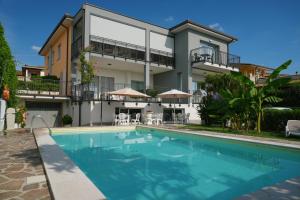 a house with a swimming pool in front of a building at Appartamenti da Mirella in Lazise