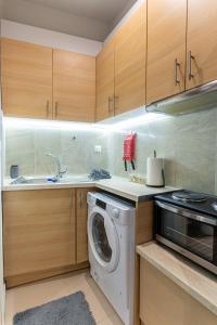 a kitchen with a washing machine and a sink at Lion's Cave suite No 1. in Kalamata