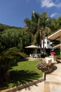 a garden with a table and chairs and palm trees at B&B Cavalieri in San Felice Circeo