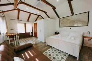 Un dormitorio con una gran cama blanca y una mesa en Villa Libosad en Jičín