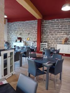 a dining room with tables and chairs and a brick wall at Eliseo's rooms in Triei