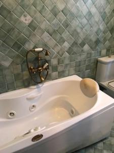 a white bath tub in a bathroom with a toilet at Villetta Indipendente in San Zeno di Montagna