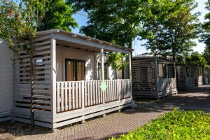 a wooden cabin with a white fence and trees at hu Roma Camping In Town in Rome
