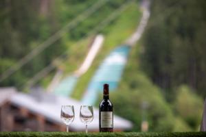 a bottle of wine sitting next to two wine glasses at Duplex stylé face à l'Aiguille du Midi in Chamonix-Mont-Blanc