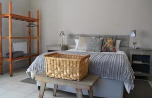 1 dormitorio con 1 cama con una cesta en un banco en Favour House en Bethlehem
