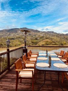 a table and chairs on a deck with a view at 1714 Hotel Boutique Guatapé in Guatapé