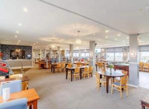 ein Restaurant mit Tischen, Stühlen und einem Billardtisch in der Unterkunft Villa sea view 3-bed heated pool eat bar kids park in Lowestoft