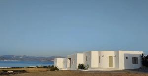 a row of white buildings with the ocean in the background at White House with Sea View in Ambelas
