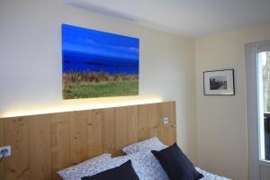 Un dormitorio con una cama con un cuadro en la pared. en Le 59 Vue Mer, en Villers-sur-Mer