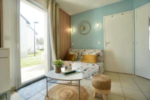 a living room with a couch and a table at Swing *piscine*Golf* in Quéven