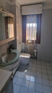 uma casa de banho com um lavatório, um WC e um espelho. em Alicia em Bérgamo