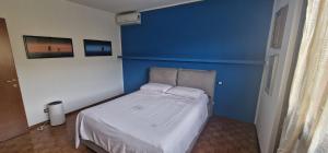 un letto in una camera con parete blu di Alicia a Bergamo