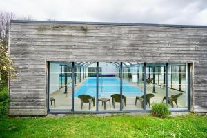 a house with a swimming pool and windows at Swing *piscine*Golf* in Quéven
