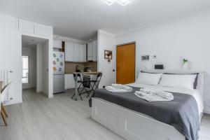 una camera bianca con un grande letto con asciugamani di Santa Giulia Suite a Milano