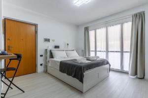 a white bedroom with a bed and a large window at Santa Giulia Suite in Milan +62 photos