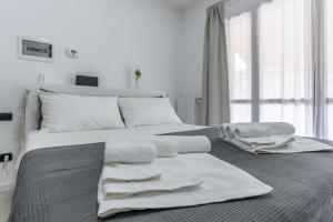 a white bedroom with a bed with towels on it at Santa Giulia Suite in Milan