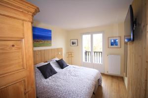 Un dormitorio con una cama y una ventana. en Le 59 Vue Mer, en Villers-sur-Mer