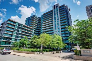 a tall building with cars parked in front of it at Stunning Condo Suite by Waterfront in Toronto