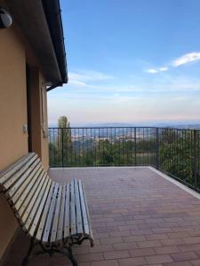 un banco sentado en un balcón con vistas en Terrazza Cassiopea, en Capradosso