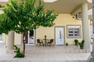 a patio with a table and chairs and a tree at Aktia Apartments, Preveza in Preveza