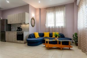 a living room with a blue couch and yellow pillows at Aktia Apartments, Preveza in Preveza