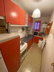 eine Küche mit roten Schränken und einem Herd mit Backofen in der Unterkunft 4 ambientes vista al mar cochera seguridad 24hs in Mar del Plata