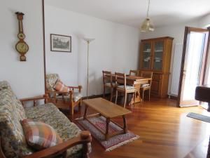 ein Wohnzimmer mit einem Sofa, Stühlen und einem Tisch in der Unterkunft Appartamento Panorama Lago di Ledro in Mezzolago
