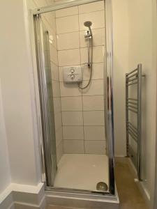 a shower with a glass door in a bathroom at Sarsfield Hostel in Dublin