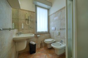 a bathroom with a sink and a toilet and a window at Camere da Mirella in Lazise