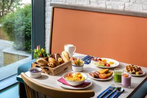 a table with plates of food and bread on it at Leonardo Hotel Brighton in Brighton & Hove +37 photos