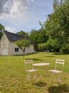 duas cadeiras e uma mesa num quintal em Le Verger de Sophie em Sainte-Geneviève-lès-Gasny