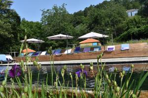 a boat with chairs and umbrellas on the water at Drop-Inn Nature, Relax, Hike and SKATE in Ponte da Barca