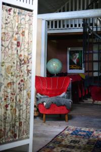 a red chair with a stuffed animal on it in a room at Henneviken BnB in Ed