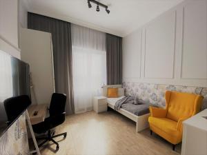 a living room with a bed and a desk and a chair at Elegancki apartament w centrum Warszawy in Warsaw