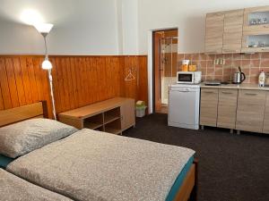 een kamer met 2 bedden en een keuken bij Garsoniera v roddiném domě in Dubice