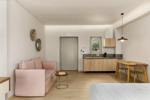 a living room with a pink couch and a kitchen at Margazi Areopolis Luxury Rooms in Areopolis