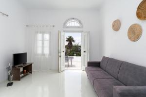 a living room with a couch and a tv at On An Island suites & apartments - Fira in Fira