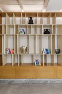 um quarto com prateleiras brancas com livros em Margazi Areopolis Luxury Rooms em Areopoli