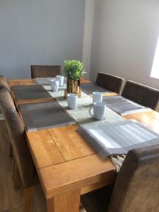 a wooden table with chairs around it with a table runner at Lovely detached Cottage, Flint in Flint